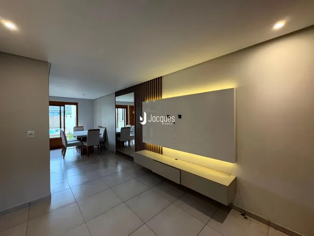 Sala de estar e jantar com piso de cerâmica e parede decorada.