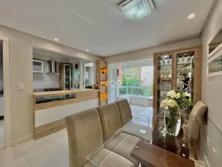 Sala de estar com decoração moderna e piso de madeira clara.