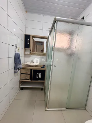Quarto com box de vidro e armário de madeira em um imóvel no Brasil.
