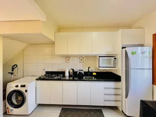 Foto de uma cozinha com armários brancos e eletrodomésticos modernos.