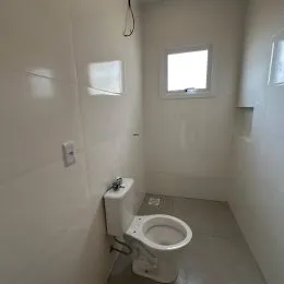 Uma foto interna mostra um ambiente com um vaso sanitário branco.