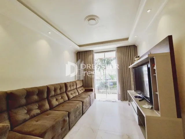 Sala de estar com um sofá marrom e piso claro.