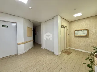 Hall de entrada com piso de cerâmica claro e paredes brancas.