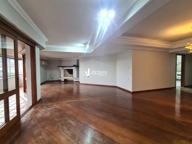 Interior de uma sala com piso de madeira e lareira em um imóvel no Brasil.