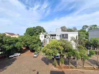 Foto da fachada de uma residência em Lajeado, Brasil, com área externa arborizada.