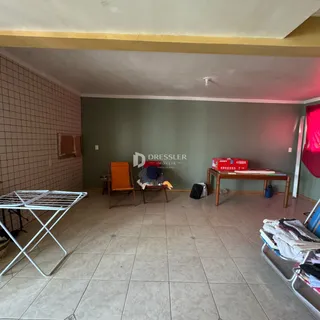 Ambiente interno de uma sala com piso de cerâmica e paredes em tom verde.