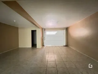 Hall de entrada com piso de cerâmica e porta de garagem visível.
