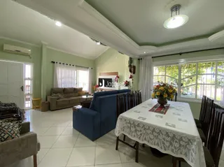 Sala de estar com sofá e piso claro em uma residência.