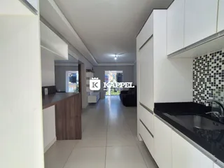Vista interna de uma cozinha com armários brancos e piso claro.