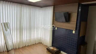 Ambiente interno com cortinas brancas e piso de madeira.