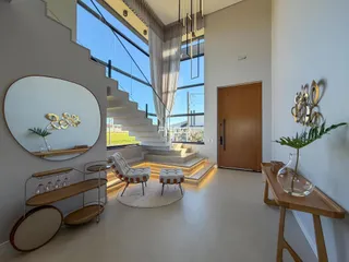 Sala de estar moderna com grandes janelas e escadaria em um imóvel em Lajeado.