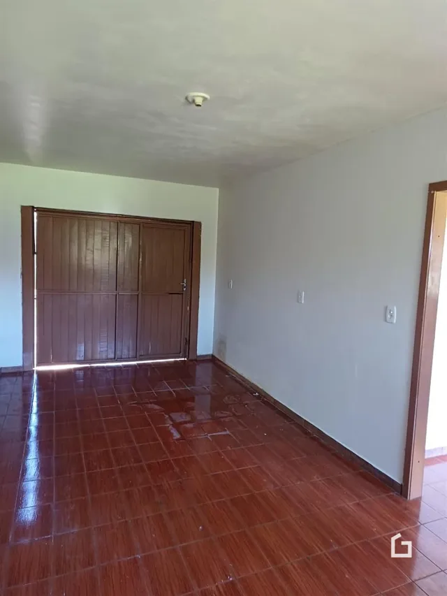 Vista interna de um ambiente com piso de cerâmica e portas de madeira.