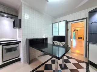 A cozinha apresenta um piso xadrez preto e branco e revestimento de azulejos brancos.