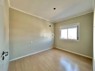 Sala de estar com piso de madeira clara e paredes em tom neutro.