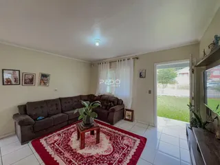 Sala de estar com sofá e tapete vermelho em uma residência.