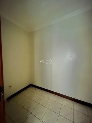Vista interna de um corredor com piso de cerâmica clara.