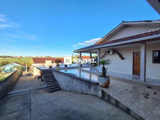 Fachada de uma casa com área externa e piscina.