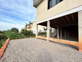 Vista externa da fachada de uma residência em Lajeado, Brasil, com área de cascalho na frente.
