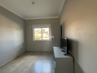 Ambiente interno de uma sala com janela e armário.