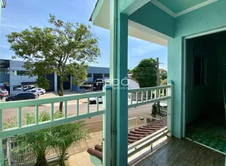 Vista da fachada de uma residência em Lajeado, Brasil, com uma varanda e vegetação.