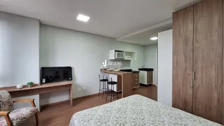 Quarto com decoração moderna e cozinha integrada.