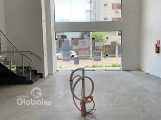 Vista interna de um espaço com escadaria e porta de vidro que dá para o exterior.
