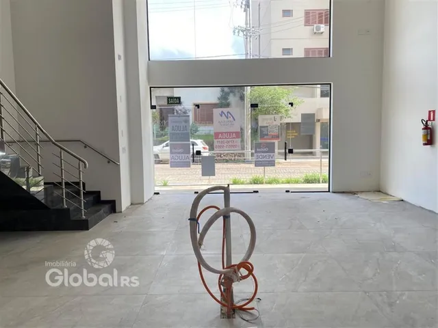 Vista interna de um espaço com escadaria e porta de vidro que dá para o exterior.