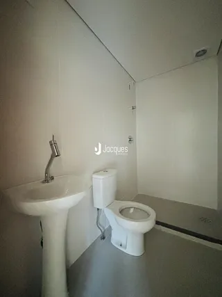 A foto mostra o interior de um banheiro com pia e vaso sanitário.
