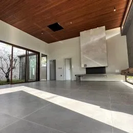 Vista ampla de um ambiente interno com forro de madeira e piso claro.