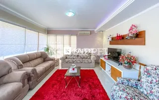 Sala de estar com sofá e tapete vermelho.