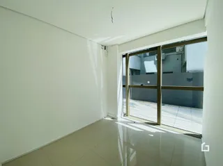 Interior de um ambiente com parede branca e grande janela.