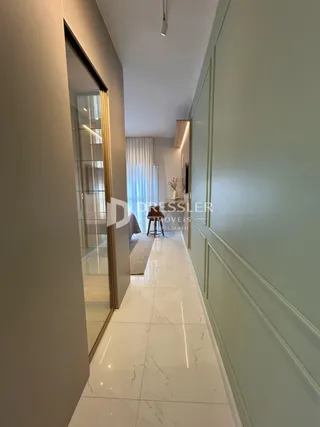Corredor interno de uma residência com piso de mármore claro.