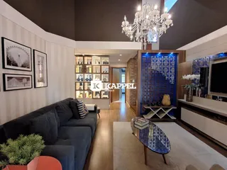Sala de estar moderna com sofá grande e iluminação de lustre de cristal.