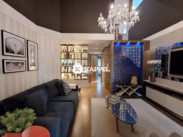 Sala de estar moderna com sofá grande e iluminação de lustre de cristal.