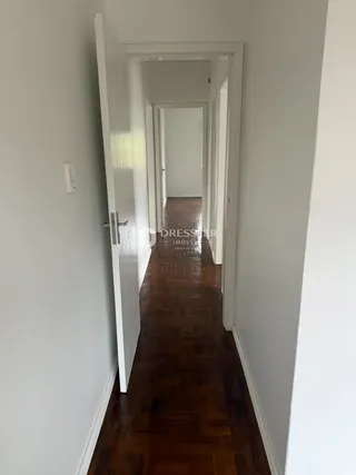 Corredor interno com piso de madeira.