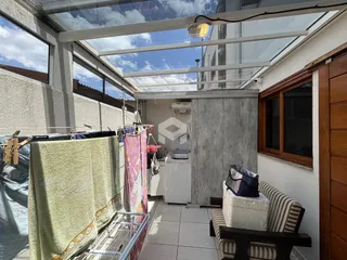 Vista interna de um espaço com estrutura de teto de vidro e móveis pendurados.