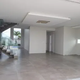 Ambiente interno amplo com piso de concreto polido e teto branco.