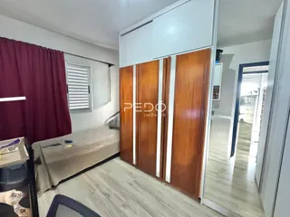 Quarto com armário de madeira e piso de madeira.