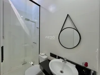 Foto de um banheiro com box de vidro e pia branca.