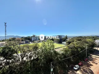 Vista aérea de uma área verde com edifícios ao fundo.