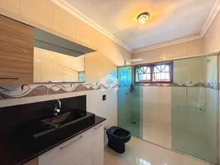 Foto de um banheiro com revestimento cerâmico e box de vidro.