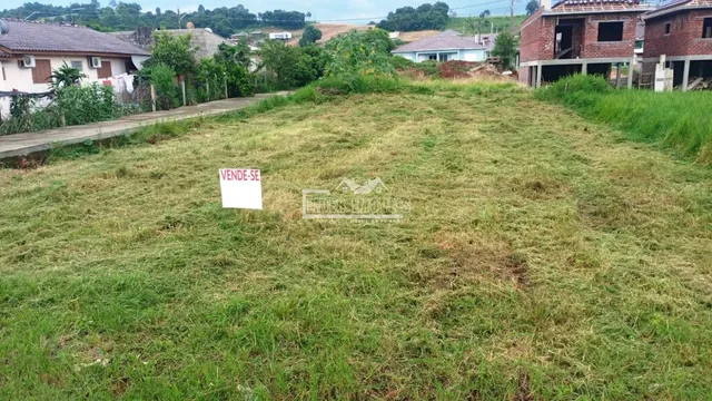Campo gramado com sinal de venda em Lajeado, Brasil.