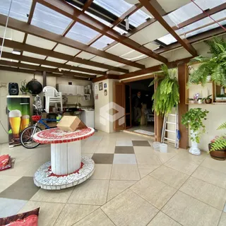 Ambiente interno de uma casa com teto de madeira e piso de cerâmica.