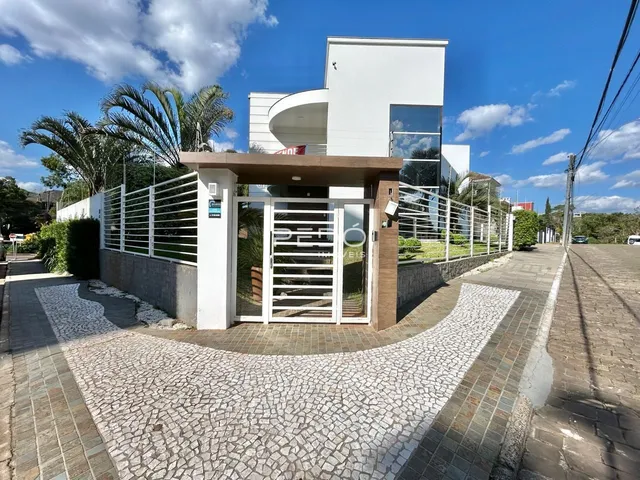Vista externa de uma residência moderna em Lajeado, Brasil, com portão e paisagismo.