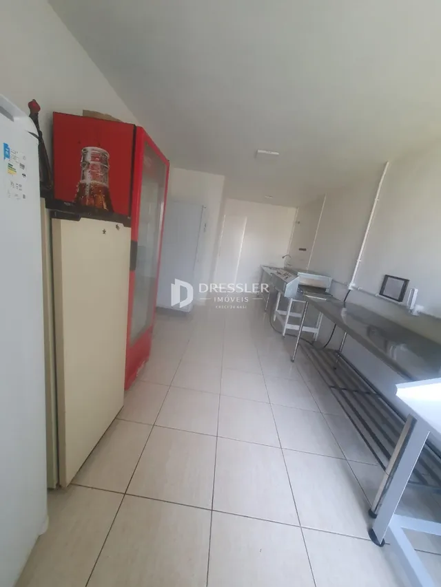 Corredor interno de uma residência com piso de cerâmica clara.