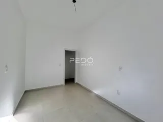 Hall de entrada de um imóvel com paredes brancas e piso claro.