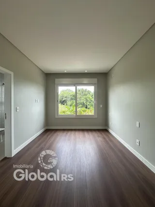 Vista interna de um ambiente com piso de madeira e paredes cinzas.