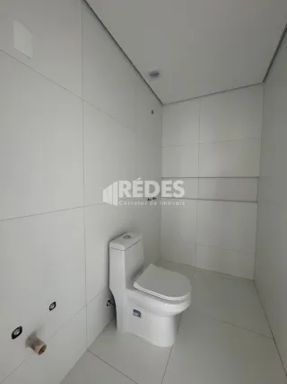 Foto de um banheiro interno com revestimento branco.