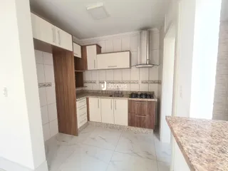 Cozinha moderna com armários brancos e detalhes em madeira.