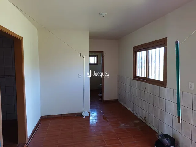 Hall de entrada com piso de cerâmica avermelhada e paredes brancas.